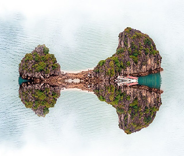 Vietnam Halong Bay cruise boat near tropical island. Aerial phot